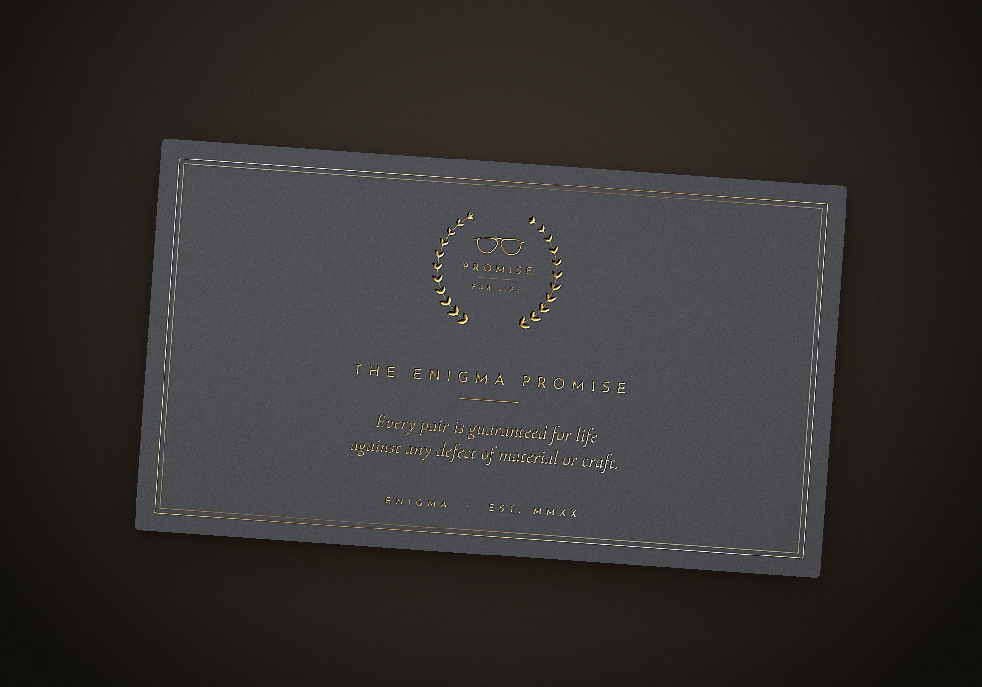 The ENIGMA Promise card, foil-stamped in gold beneath the laurel seal